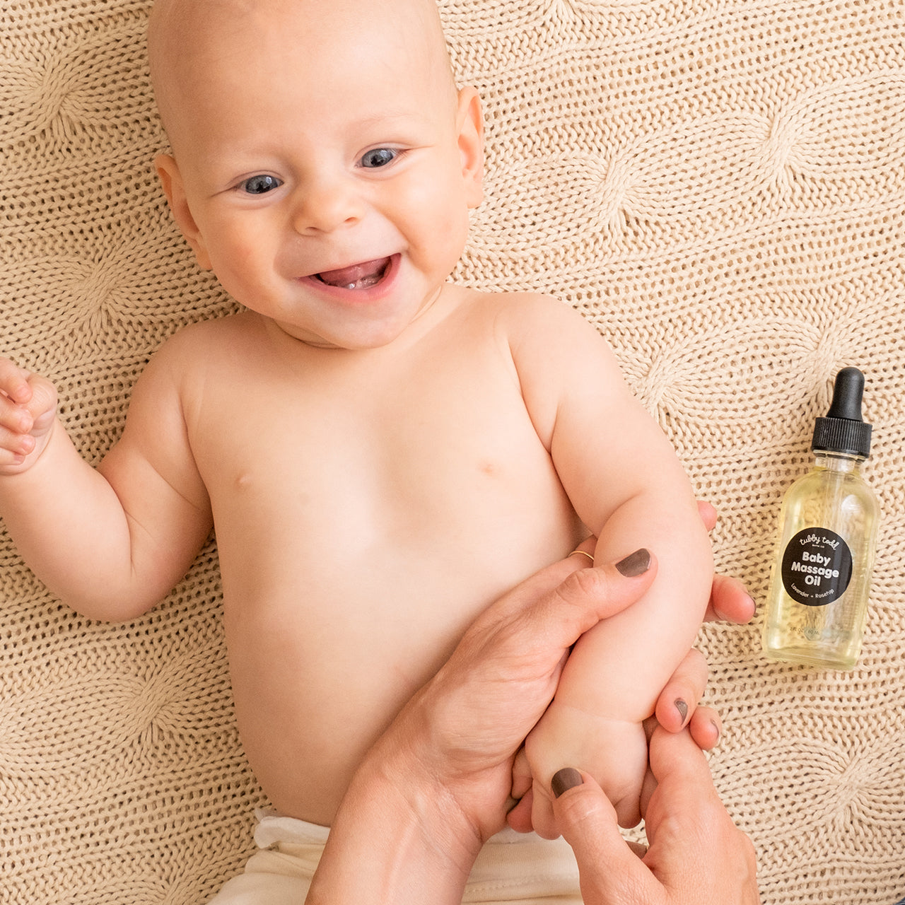 Mom is applying the baby massage oil to her baby's arm.